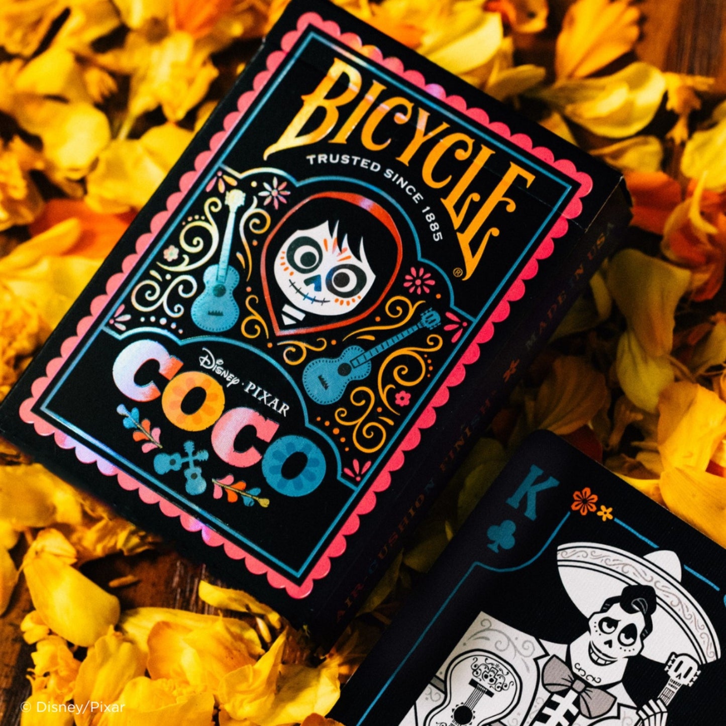 Bicycle Coco playing cards with Disney Pixar branding on a floral background
