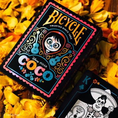 Bicycle Coco playing cards with Disney Pixar branding on a floral background